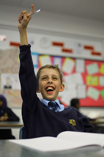 Boy in class holding his hand up